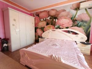 克洛佩夫尼茨基Шевченко 1的卧室配有一张墙壁上粉红色鲜花的床。