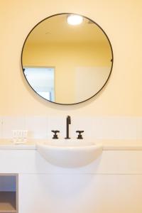 布里斯班Selina Brisbane的浴室水槽和墙上的大镜子