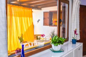 特吉塞Casa Tamai, ideal para familias en el centro de la isla的客房设有带黄色窗帘的大窗户。