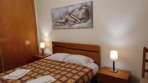 蓬塔德尔加达Dona Matilde的酒店客房,配有一张床和两盏灯