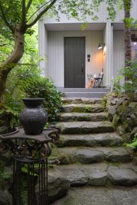 箱根Hakone Mori No Yado " vintage lodge in the nature of HAKONE"的坐在房子前面桌子上的花瓶