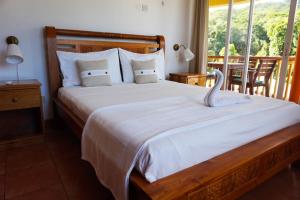 安塞罗亚莱泰蕾兹别墅酒店的一间卧室设有一张大床和大窗户