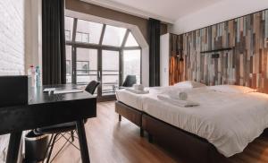 布兰肯贝赫Hotel Cavalli by WP Hotels的一间卧室配有一张大床、一张桌子和一个窗户。
