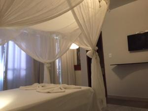 拉巴拉德纳圣米格尔帕萨达格恩盖酒店的白色的床,带白色窗帘的天篷