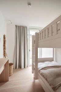 诺德奈Inselhouse的白色的卧室设有双层床和窗户。