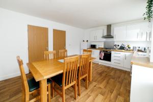 DunstonTown House D的厨房以及带木桌和椅子的用餐室。