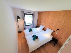 夏蒙尼-勃朗峰La Cordee - Charmant Appartement - 4 personnes的两张位于房间的床,配有两个绿色枕头