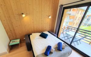 夏蒙尼-勃朗峰La Cordee - Charmant Appartement - 4 personnes的一间卧室配有一张带两个蓝色枕头的床