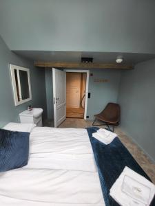 奥镇Brygga Restaurant and Rooms的一间带白色大床的卧室和一间浴室