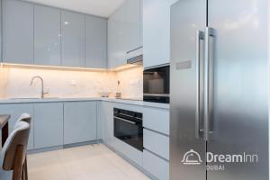 富查伊拉Dream Inn Apartments - Address Beach Residence Fujairah的厨房配有白色橱柜和不锈钢冰箱