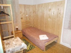 ColtanoPigreco的一间小卧室,配有一张床和木墙