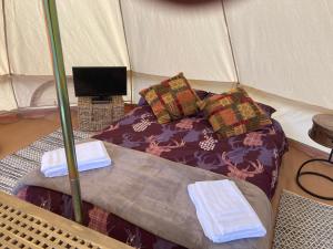 罗斯林Roslin Glamping的帐篷内的一张床位,上面有两条毛巾