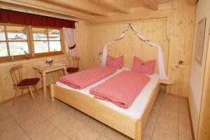 施万高Jägerhof und Jägerstadel的木制客房内的一间卧室,配有一张床
