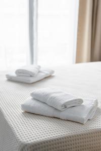 塞萨洛尼基Boho Rooms的床上有两条白色毛巾