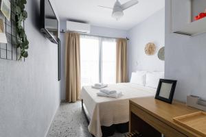 塞萨洛尼基Boho Rooms的一间卧室配有一张床、一张书桌和一个窗户。