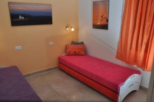 阿拉德Mory's Place - Luxurious Holiday Apartment的坐在房间的角落里的红色沙发