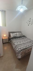 里雄莱锡安יחידת דיור的一张床位,房间配有灯和床罩