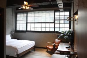 台南The Retro Tai-Pan的一间卧室配有一张床、一张书桌和一个窗户。