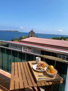 蒙达卡Mundaka best views house的阳台上的餐桌上放着一盘食物