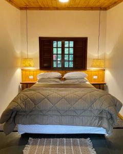 圣本图-杜萨普卡伊Rancho do Paioleiro - Suites的一间卧室配有一张带窗户和两盏灯的床。
