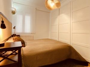 拉科鲁尼亚Quiet and Cozy Downtown Apartment的一间卧室配有一张床、一张桌子和一个窗户。