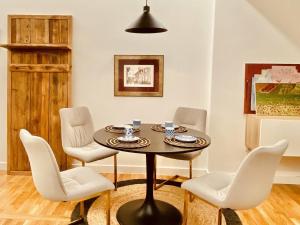 拉科鲁尼亚Quiet and Cozy Downtown Apartment的一间带桌子和白色椅子的用餐室