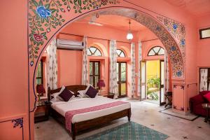 斋浦尔Diggi Palace A Luxury Heritage Hotel的一间带一张床铺的卧室,位于一个拱形的房间
