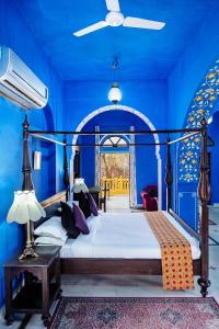 斋浦尔Diggi Palace A Luxury Heritage Hotel的一间卧室配有一张蓝色墙壁的床