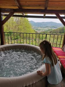 瓦拉日丁托普利采Villa Marijana的站在热水浴缸中的一个小女孩