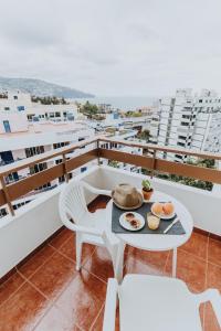 丰沙尔Casa Branca Apartments by Wanderlust Madeira, vacation rentals的阳台配有餐桌,上面有食物