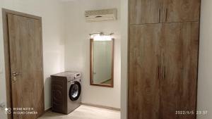 加藤-达拉特索Sunshine Apartments的一间带洗衣机和镜子的浴室