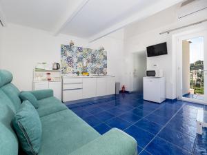 波西塔诺Santoro Suite的一间带绿色沙发的客厅和一间厨房