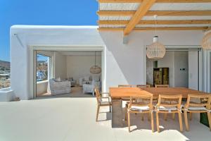 普拉迪斯亚罗斯The Absolute beachfront luxury villa的一间带木桌和椅子的用餐室