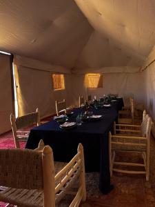 Foum ZguidBivouac Les Nomades & Foum zguid to chegaga tours的帐篷内的用餐室,配有桌椅