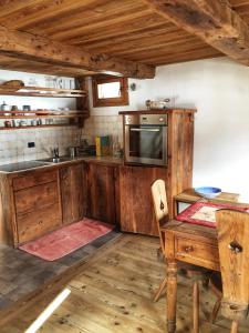 尚波吕克Piccolo e accogliente rascard CIR 0060的厨房配有木制橱柜、桌子和水槽。
