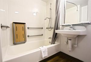 东不伦瑞克东布伦兹维克6汽车酒店的浴室设有水槽、浴缸和镜子