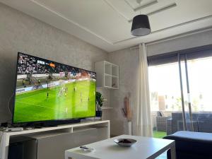 萨伊迪耶Appartement de LUXE Marina SAIDIA avec vue sur PISCINE Résidence TAMARIS的客厅配有大屏幕平面电视