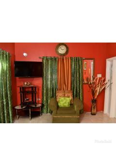 波特莫尔Caribbean estate deluxe 2的客厅配有椅子和墙上的时钟