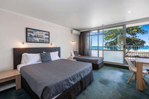 纳皮尔纳皮尔品质酒店的酒店客房设有一张床、一张书桌和窗户。