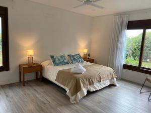 萨尔塔Acogedora y amplia casa en Salta!的一间卧室配有一张带两盏灯的床和一扇窗户。