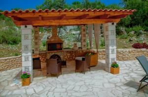 Kalamitsi AmygdaliDireti villa的露台设有带壁炉的凉亭。
