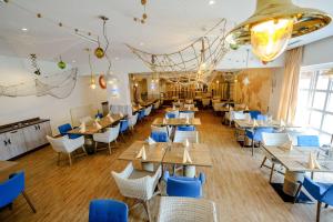 阿尔蔡Dorint Hotel Alzey/Worms的餐厅设有木桌和蓝色椅子