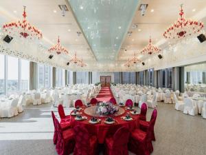 安平区福尔摩沙游艇酒店的一个带红色桌子和白色椅子的大型宴会厅
