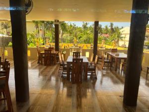 隆卡比鲁日落潜水海滩度假村的一间带木桌和椅子的餐厅以及庭院