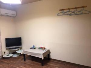 熊本アルピエa敷地内無料駐車場付き的客房设有桌子和平面电视。