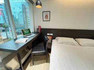 台北福尔摩莎北驿旅馆 的一间卧室配有一张床和一张带笔记本电脑的书桌