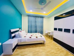 FuvahmulahHedheykuri Residence Fuvahmulah的卧室配有白色的床和蓝色的墙壁
