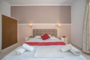 蒂锡利维ALADDIN TSILLIVi的卧室配有带红色枕头的大型白色床