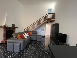 瓦拉泽Villa Silvia, indipendente con giardino privato e garage的带沙发和楼梯的客厅