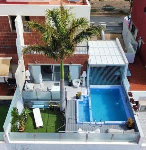 大加那利岛拉斯帕尔马斯Villa con piscina privada Palmeras Home的享有带游泳池和棕榈树的别墅的空中景致